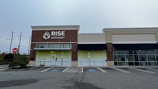 Exterior of RISE Philadelphia PA medical marijuana dispensary featuring main entrance & parking lot.